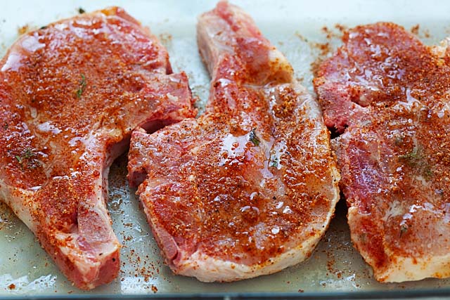 How to roast pork? Pork chops recipe with spices and sauces on a baking tray.