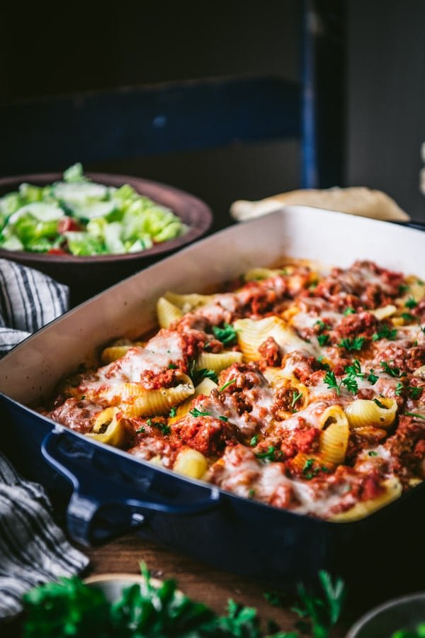 Side shot of ricotta stuffed seashells in a pan on the dinner table