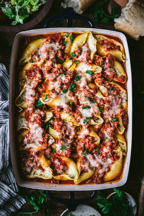 Aerial image of ricotta stuffed shell with ground beef and parsley garnish