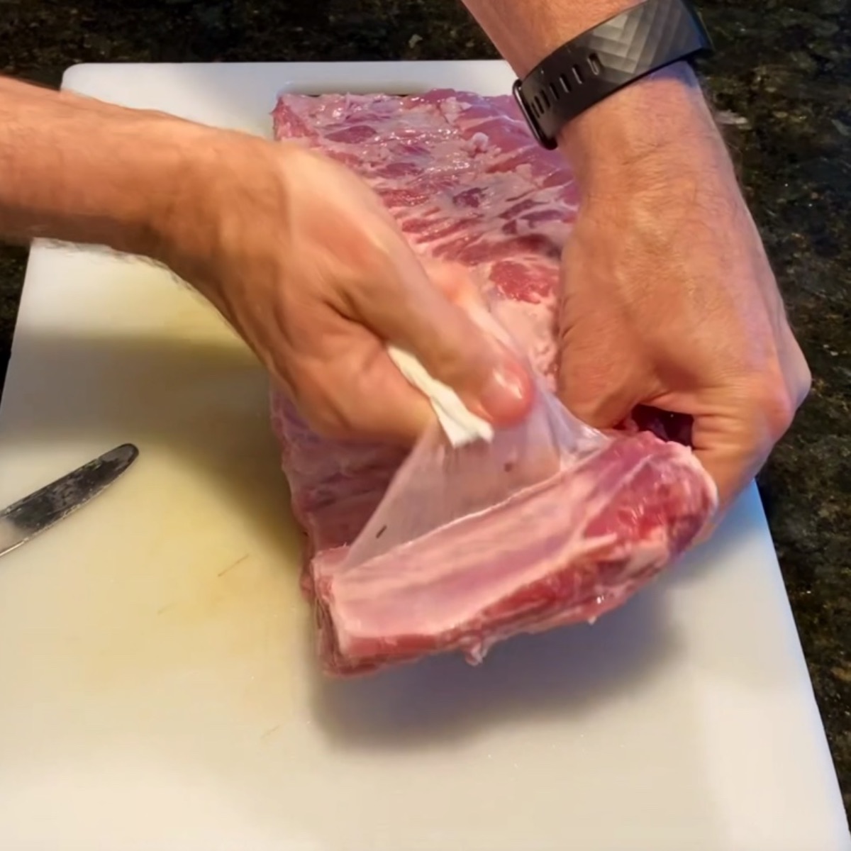 Using a paper towel to pull the membrane off of the ribs.