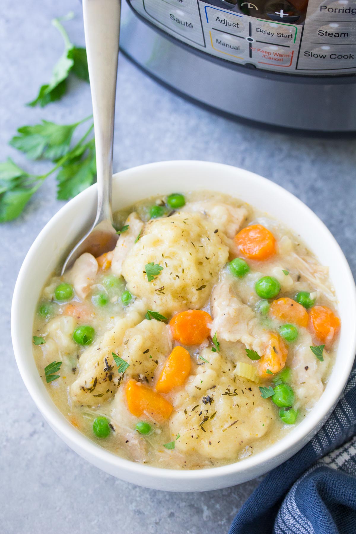 Place chicken and instant dumplings in a white bowl with a spoon.