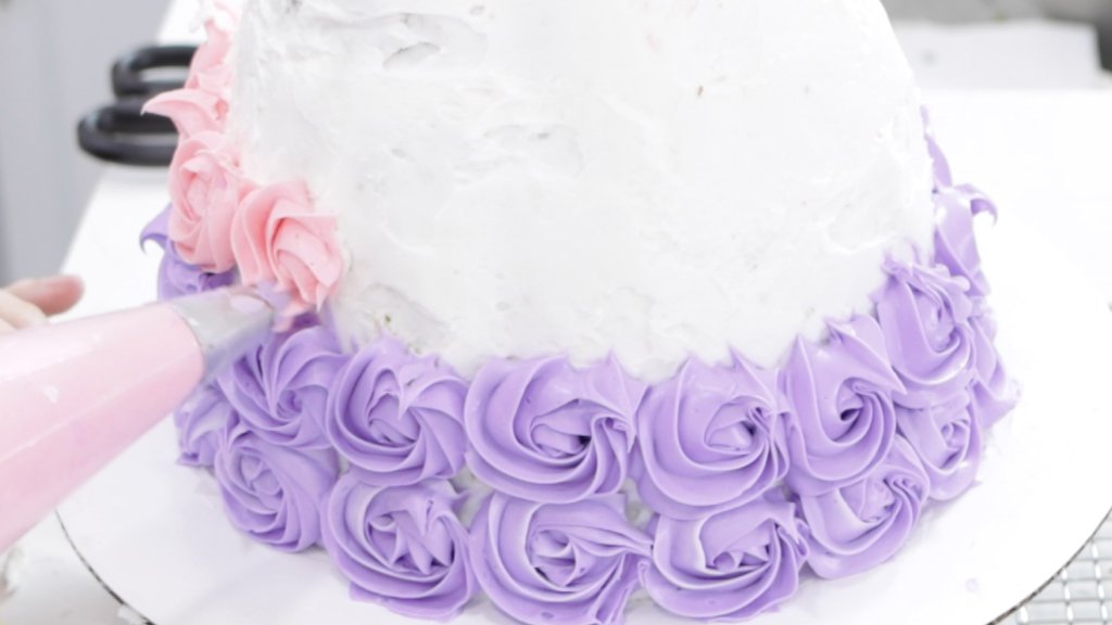 Hand piping on purple and pink flowers.