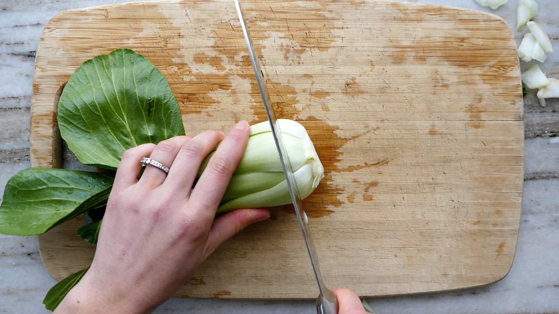 woman cutting kohlrabi root on a cutting board