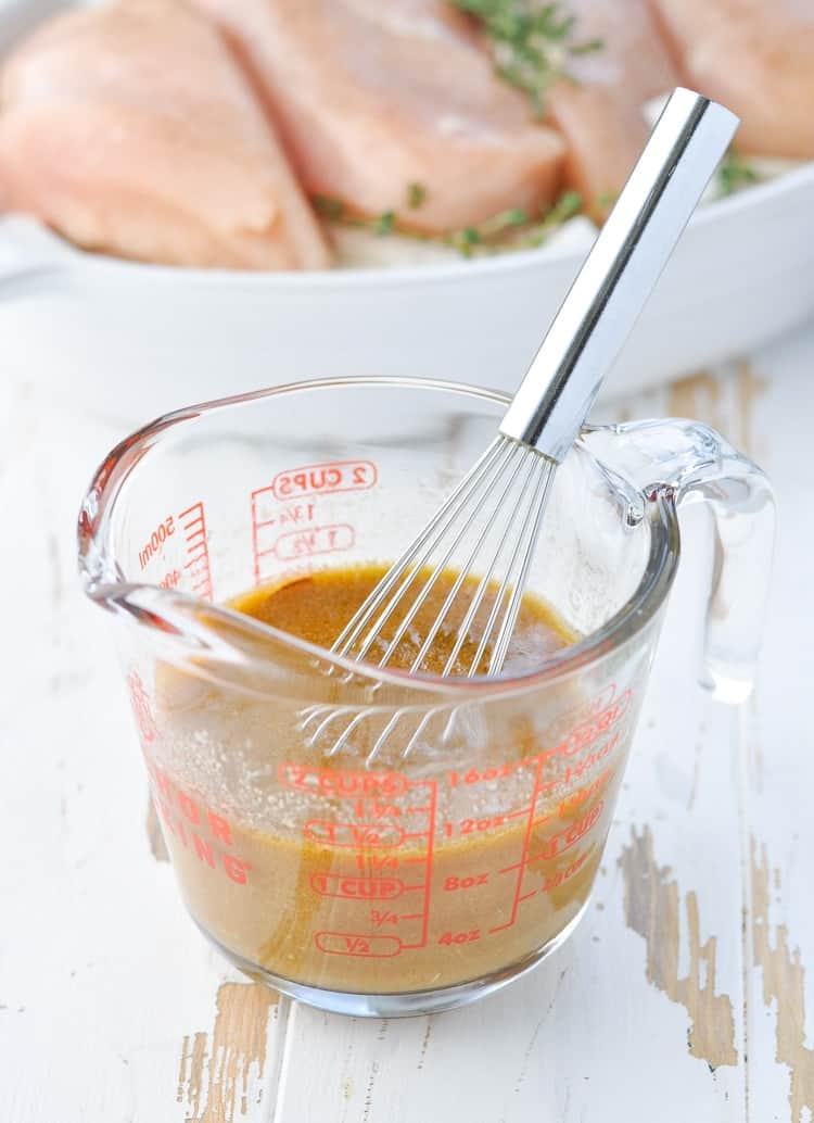 Sauce for Grilled Onion Chicken in a measuring cup with whisk