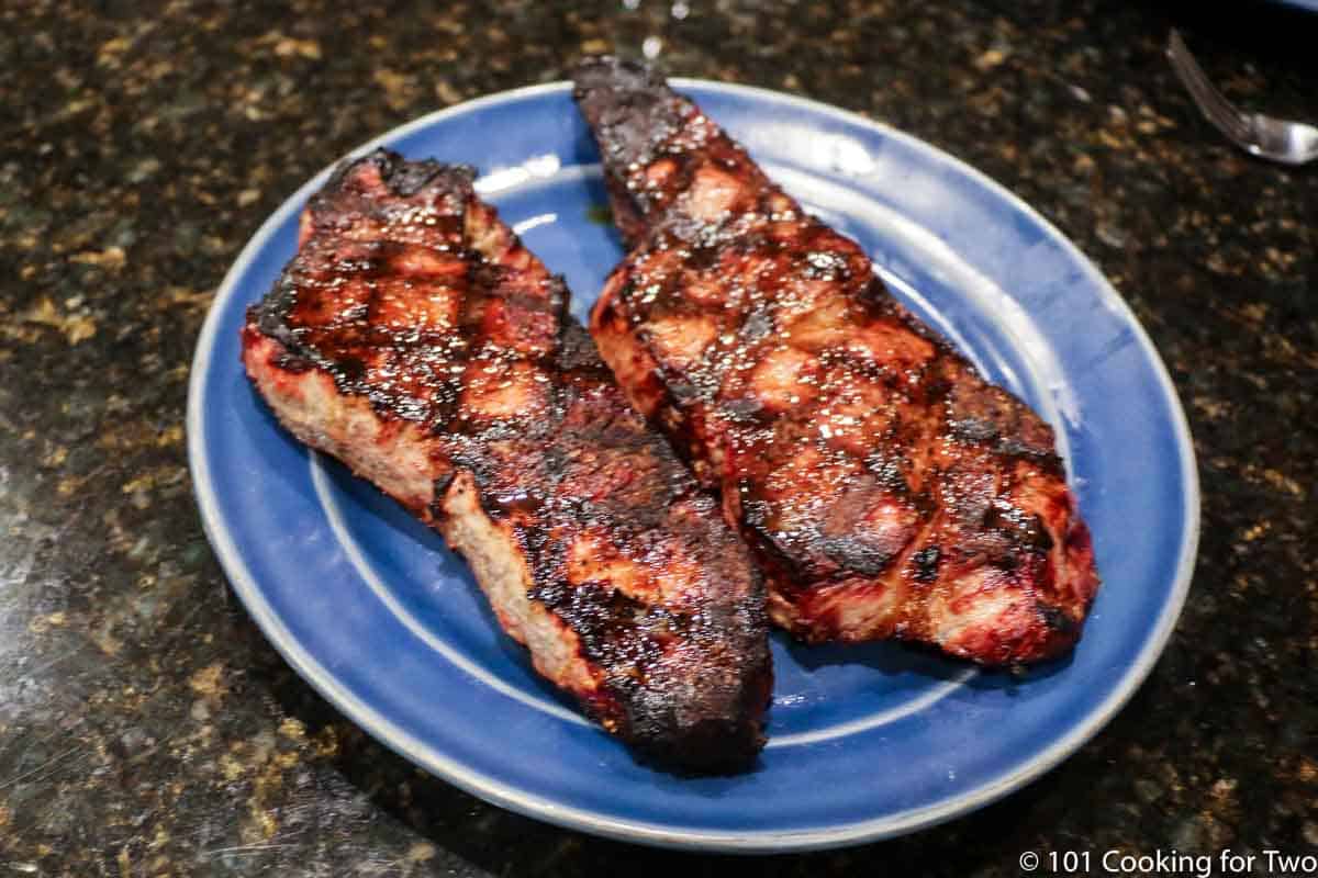 two grilled steaks on a blue plate