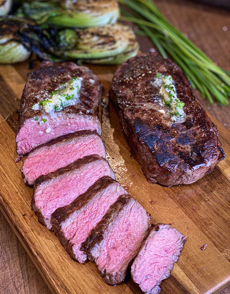 Perfect New York-style grilled steak sliced ​​on a cutting board