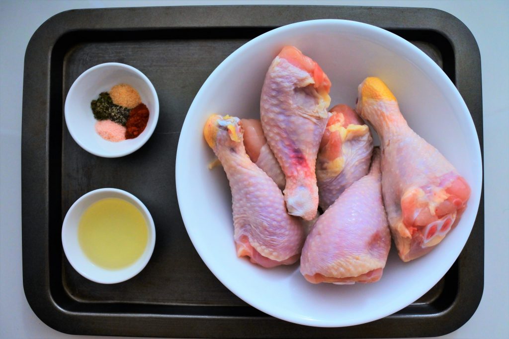 The image above shows the ingredients for pan-fried chicken thighs including raw chicken thighs, oil, and seasonings.