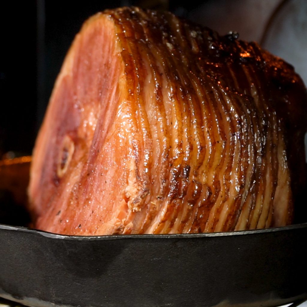 Spiral ham, smoked twice with a glaze on top, in a cast iron skillet.