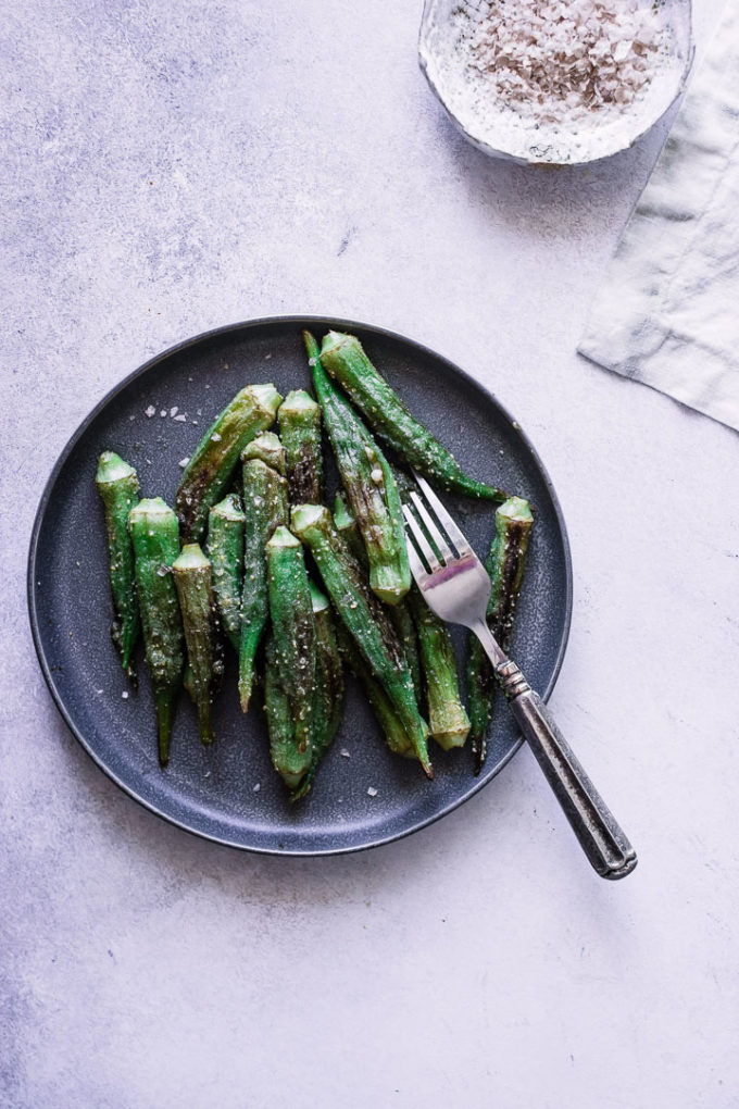 Sauté okra on a blue plate with a silver fork.