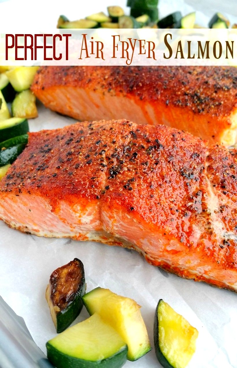 Two pieces of cooked salmon surrounded by vegetables.