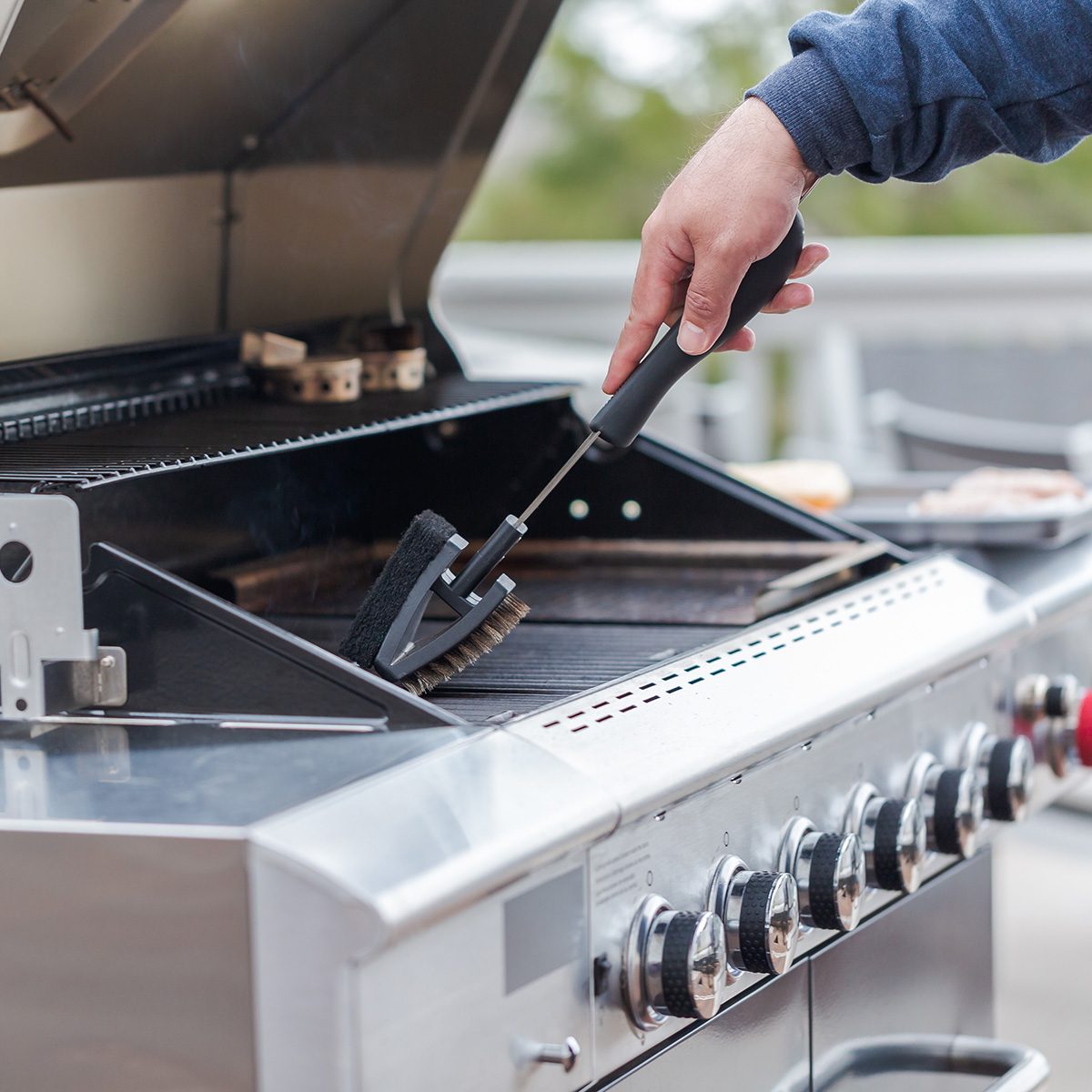 Cleaning outdoor gas grill before next grilling.