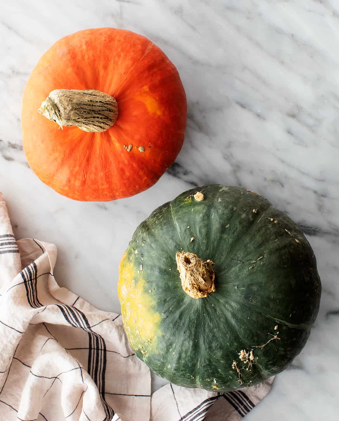 An orange and a green kabocha squash