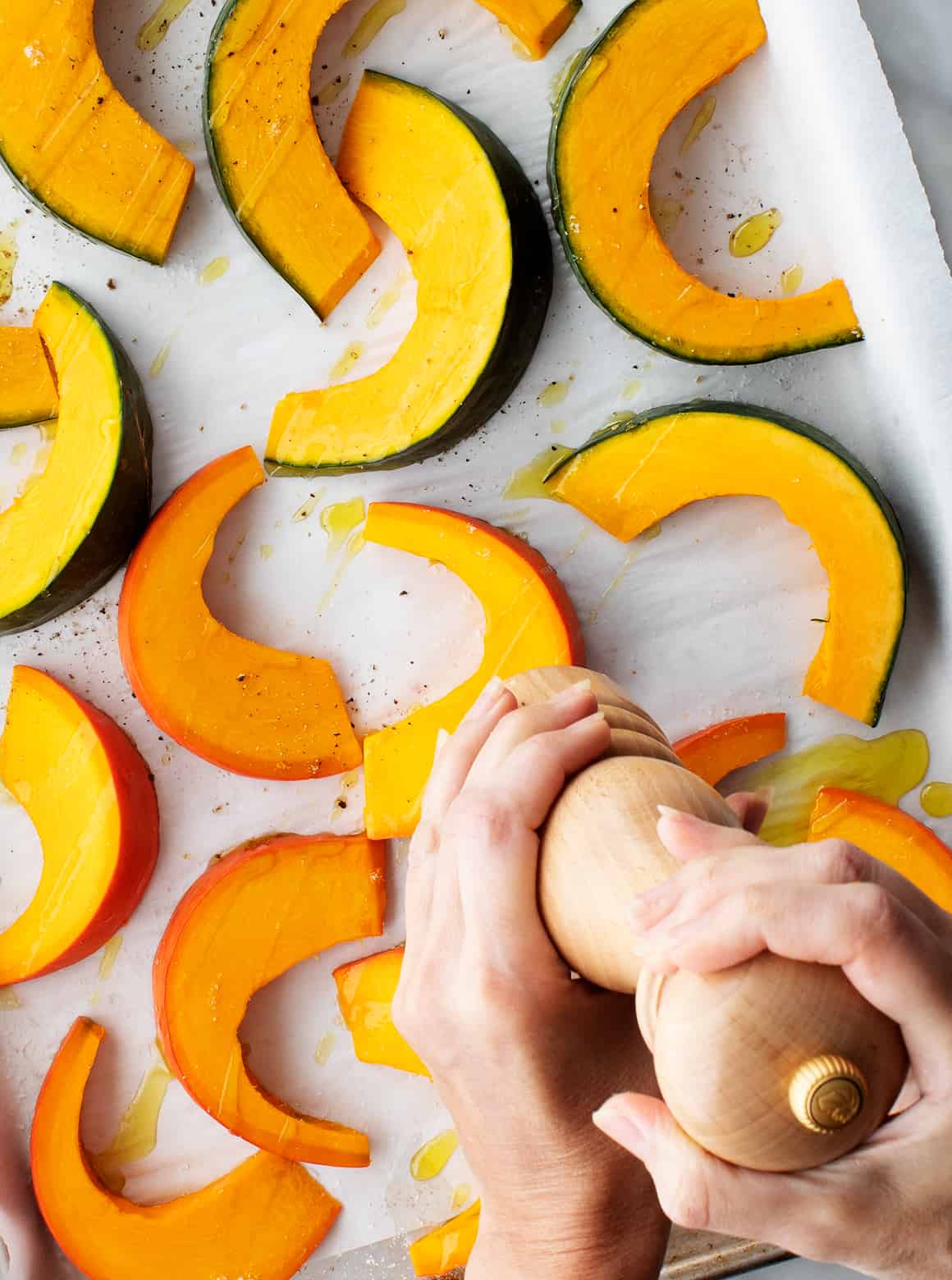 Grind pepper by hand with pumpkin seeds on a baking tray