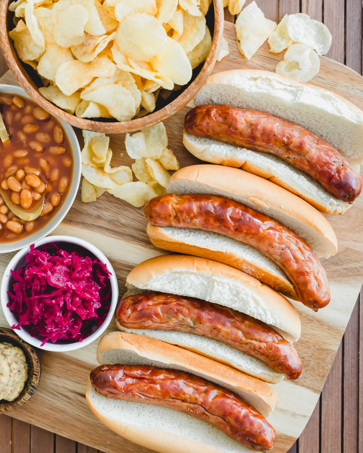 Juicy bratwurst cooked to perfection in an air fryer served with buns, fries, baked beans and sauerkraut.