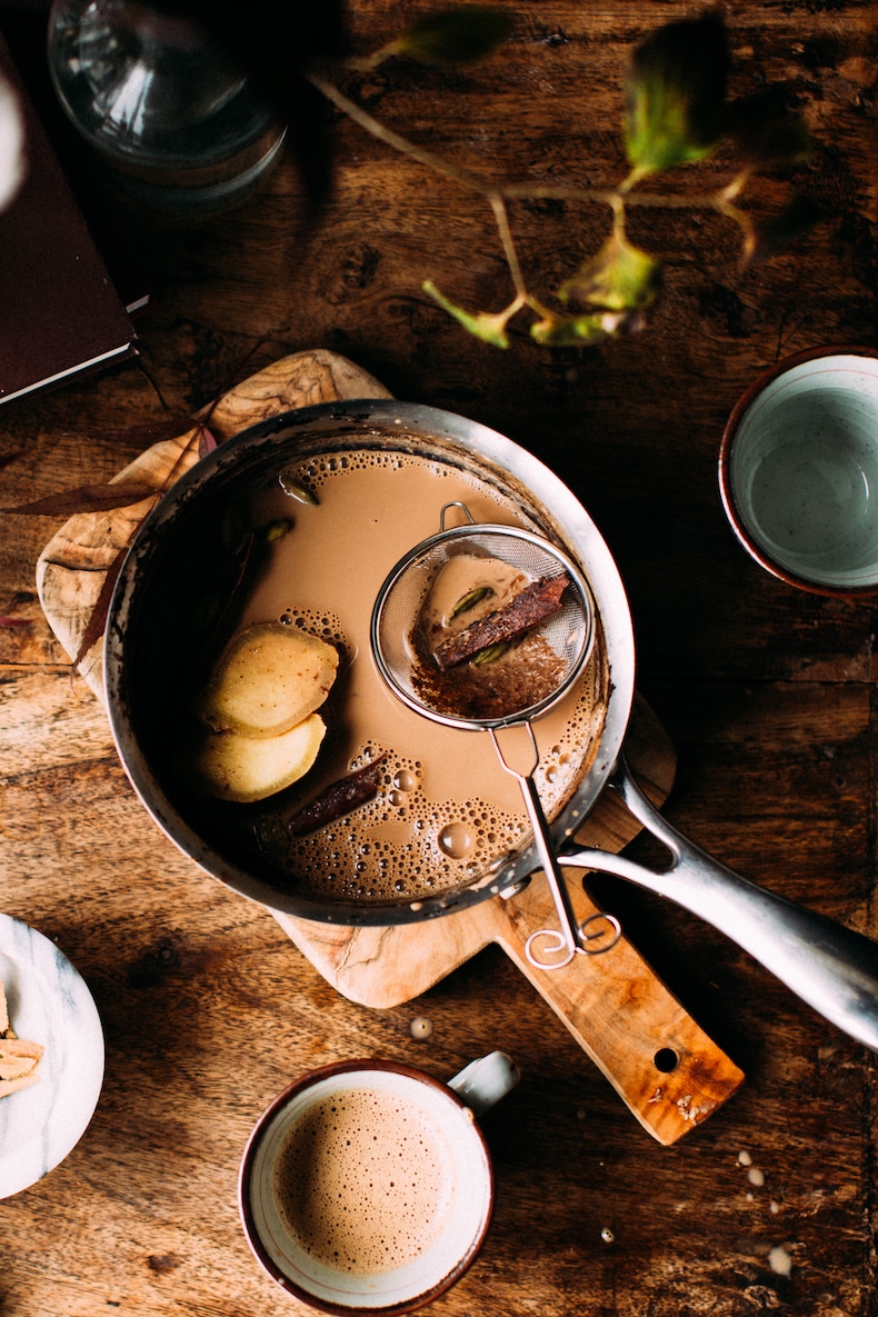 Indian chai tea from scratch in a jug with whole cinnamon