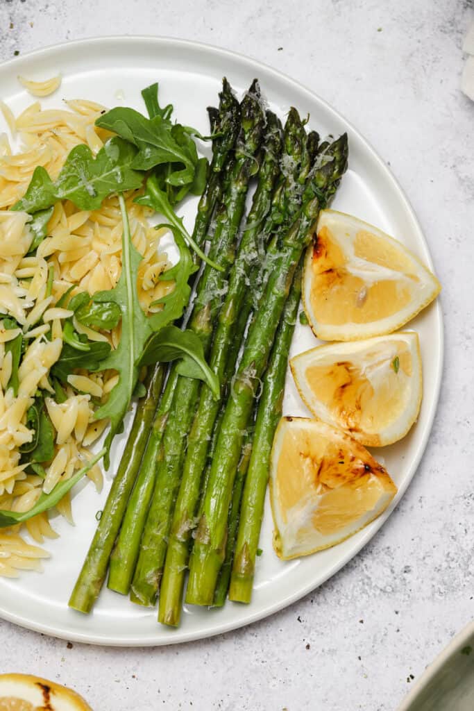 Grill asparagus in foil on a plate with orzo