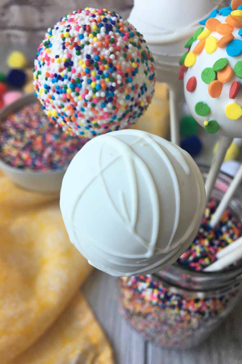 Vertical image of assorted dessert pops in a jar.