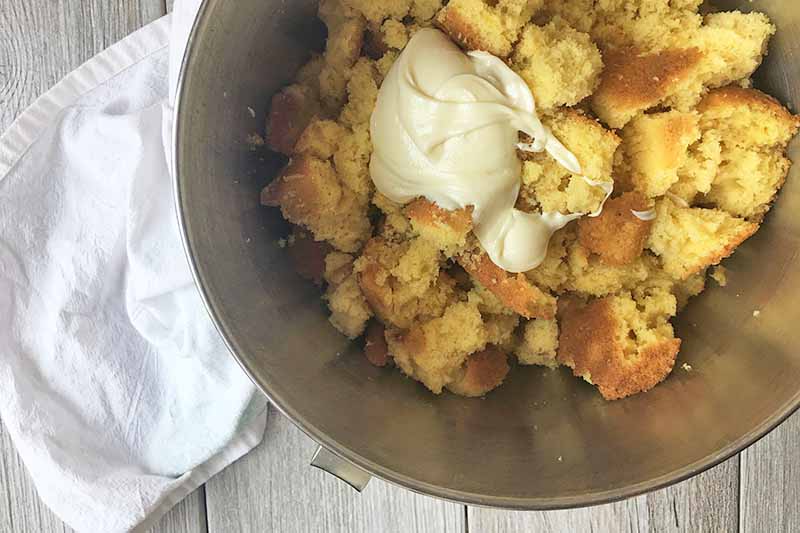 Horizontal image of crumbled yellow cake with a dollop of icing.