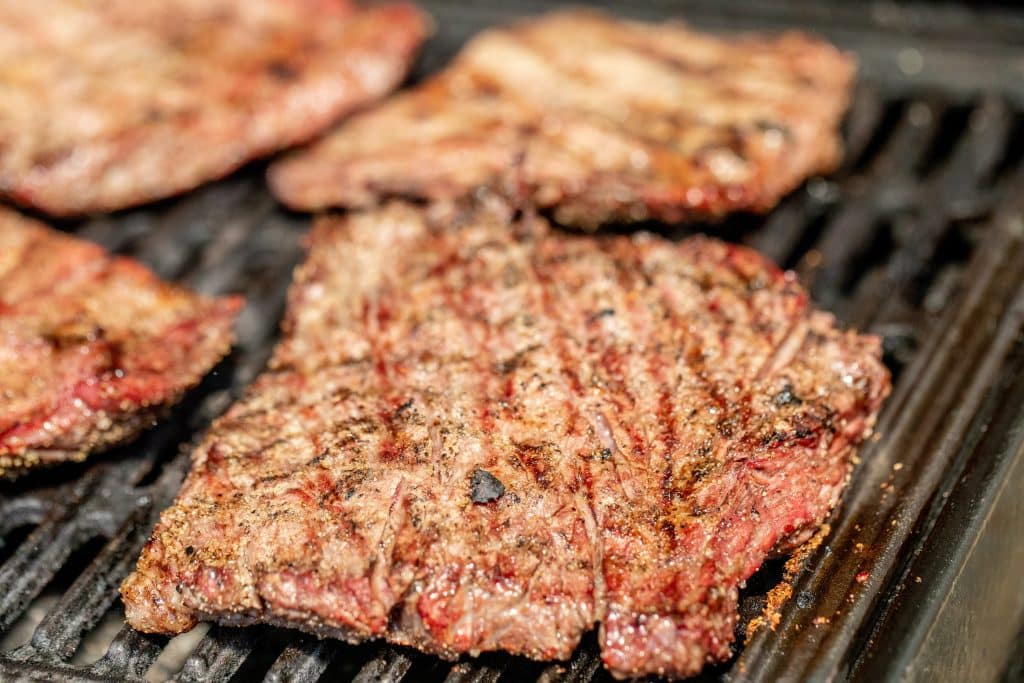 4 steaks with grill marks on the grill.