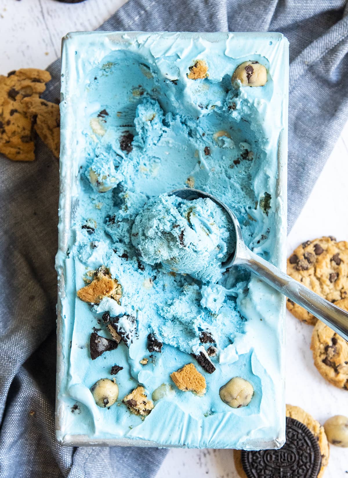 A blue monster cookie ice cream container, filled with ahoy chip cookies and oreo cookie pieces.