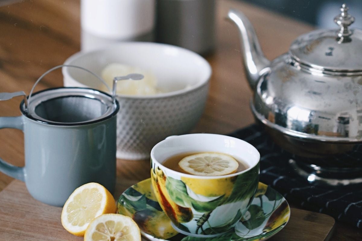silver teapot and lemon tea in a lemon patterned cup