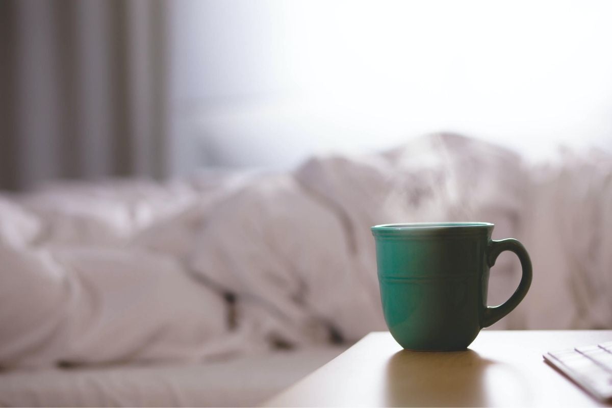 tea in green cup next to bed
