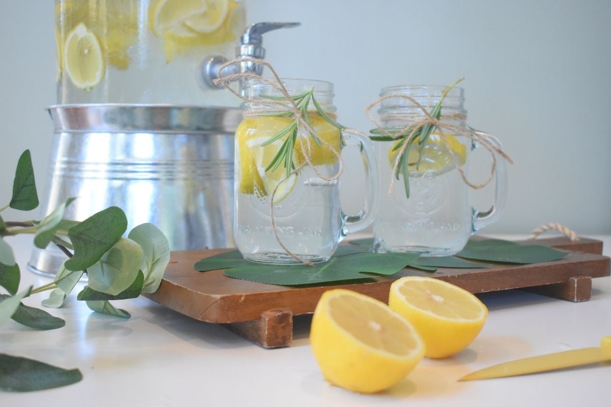 lemons in water with jug and flowers