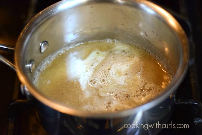 juice or beef broth is added to the roux in a saucepan.