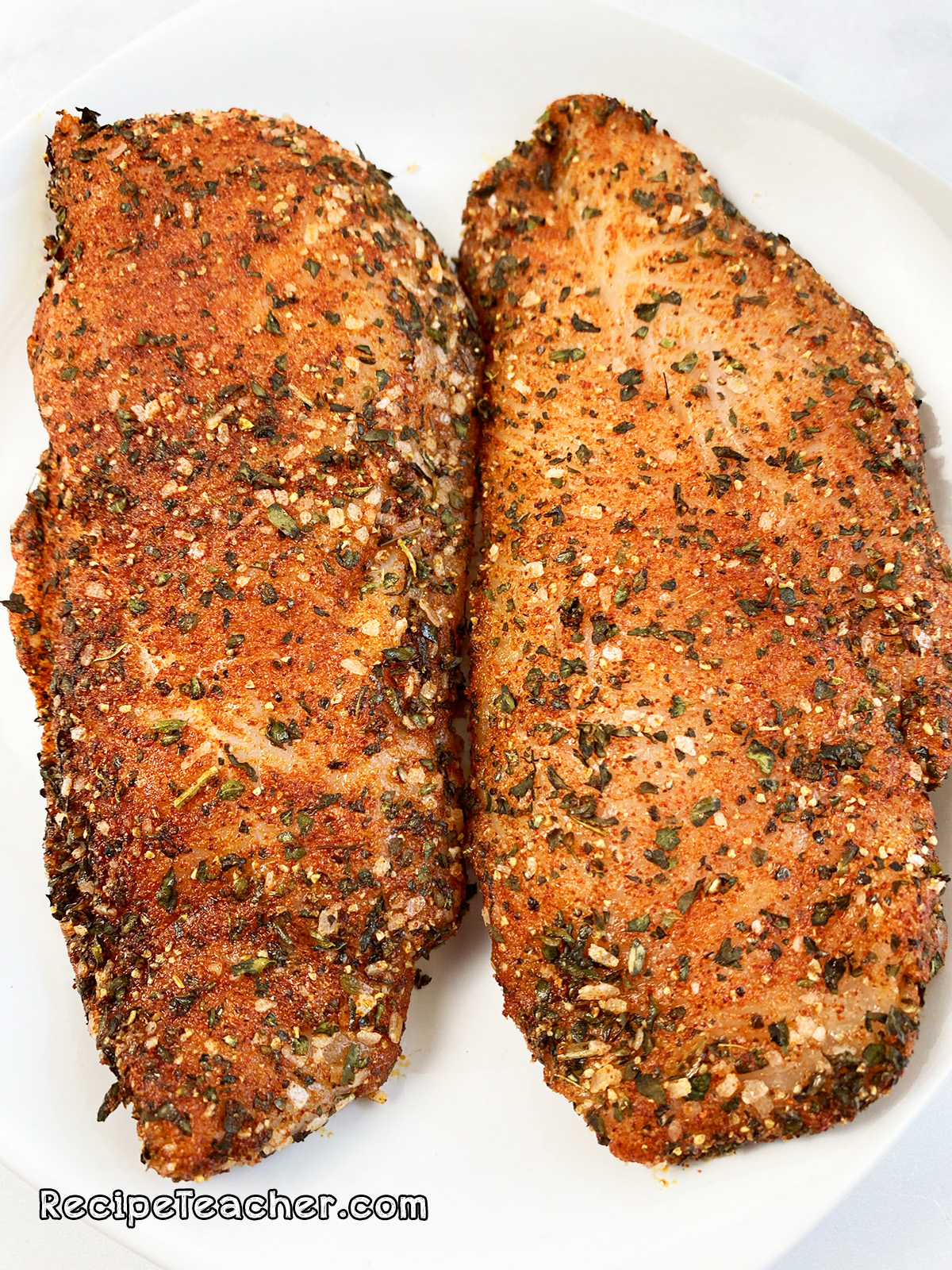 The seasoned chicken breast is ready to cook in the George Foreman Grill.