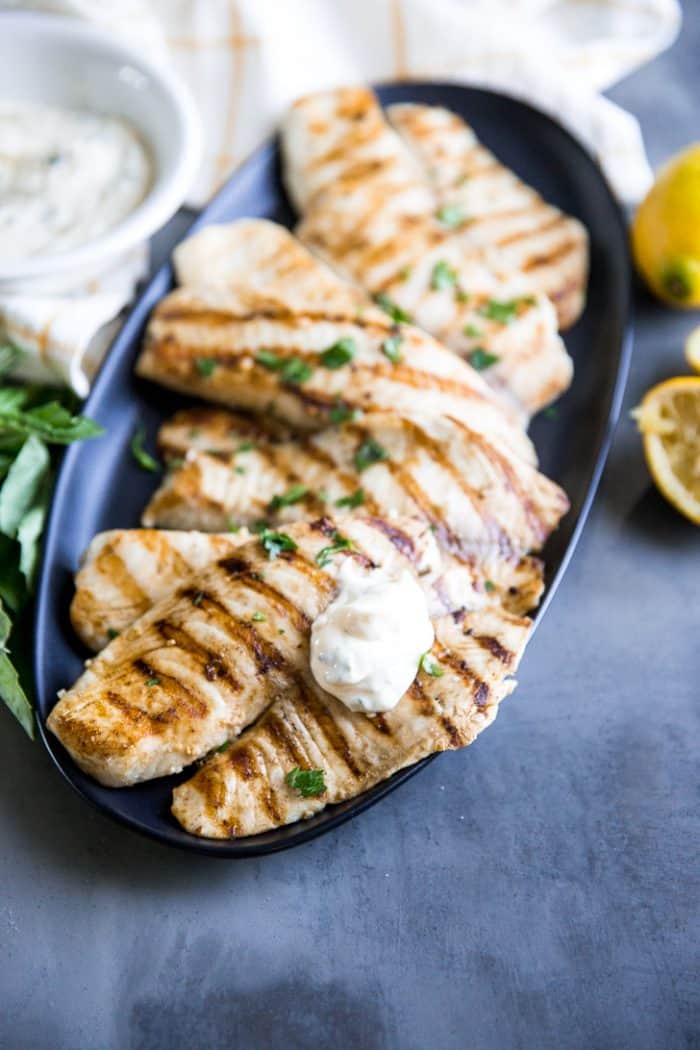 Grilled tilapia on a plate with aioli