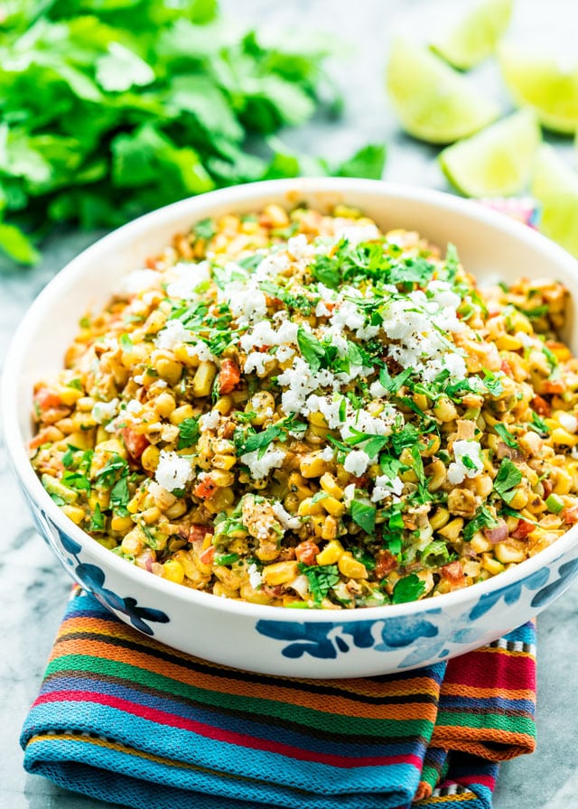 Mexican street corn salad in a bowl topped with cotija cheese and parsley