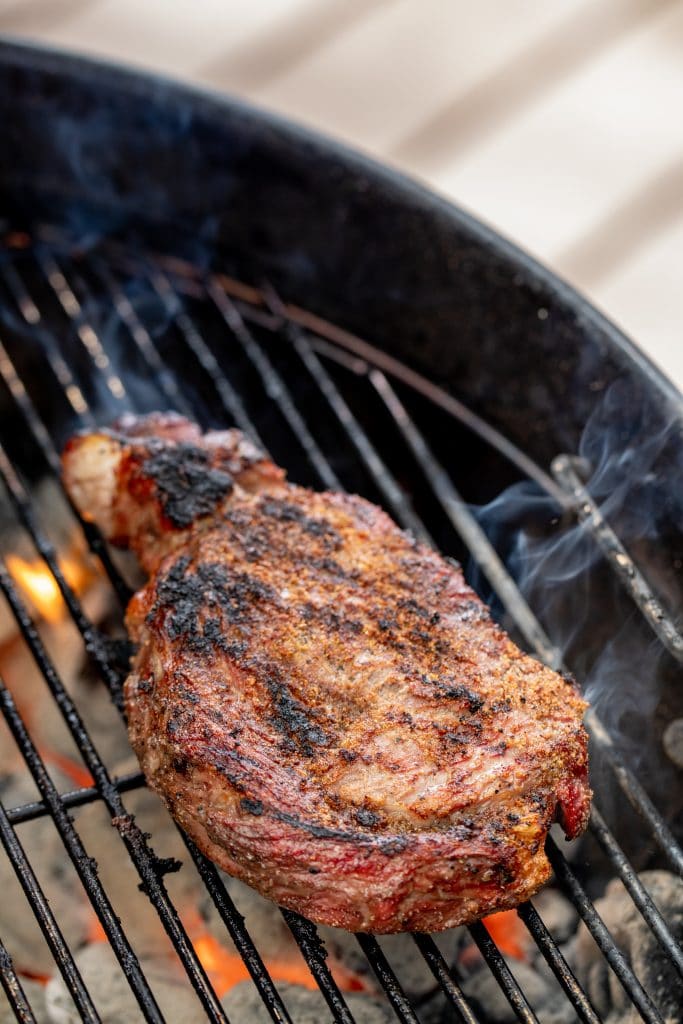 Grilled steak on a grill over hot coals.