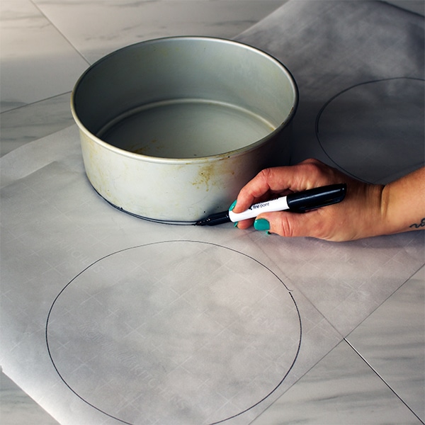 Trace the bottom of the cake pan to cut circles with parchment paper that will line the bottom of the pan.