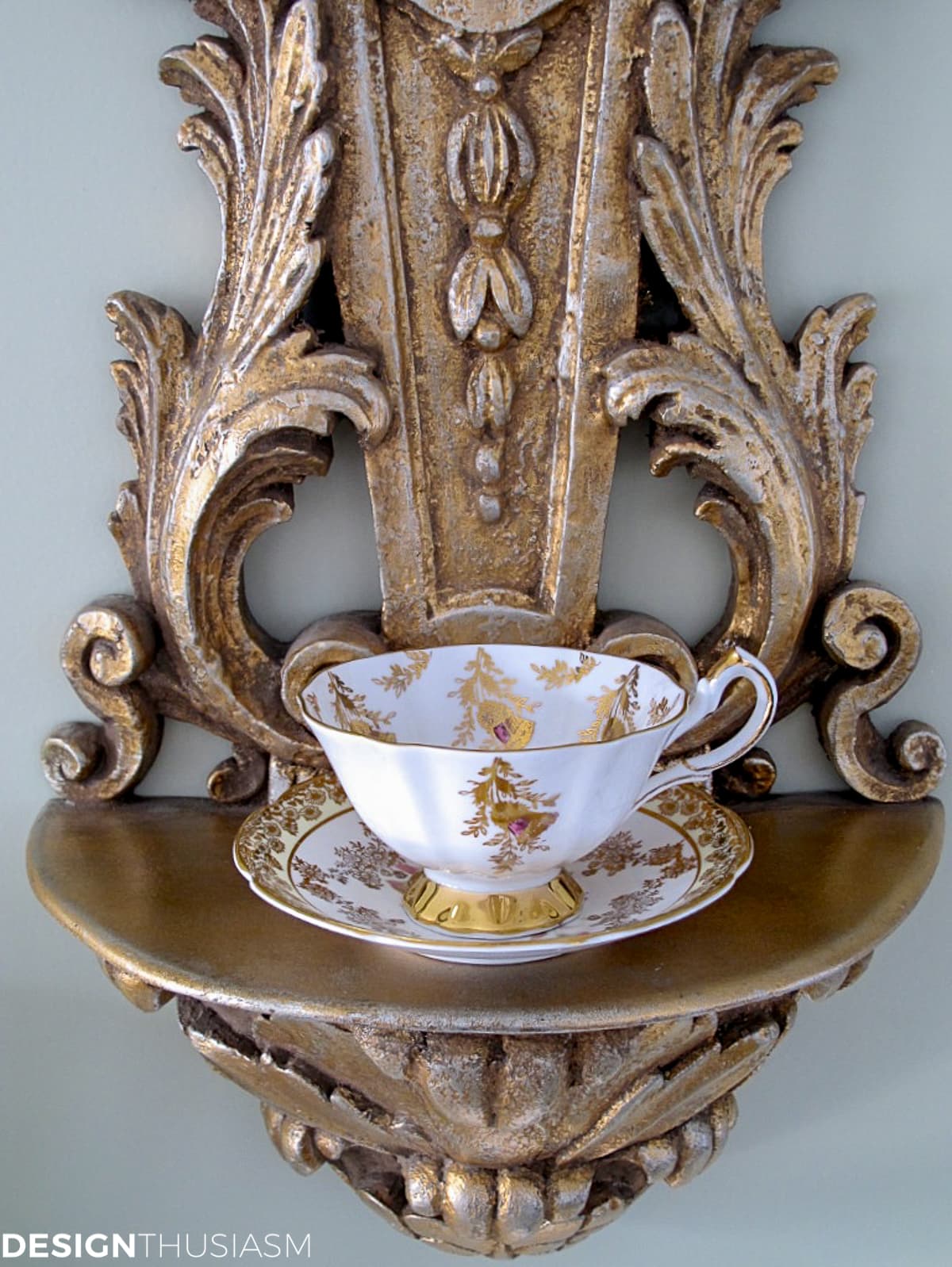 Vintage teacups and plates displayed on a wall lamp