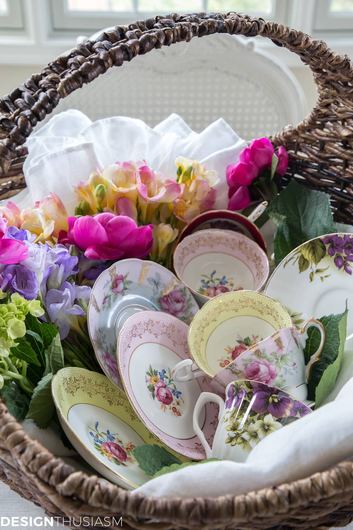 vintage tea cups and plates displayed in a flower basket