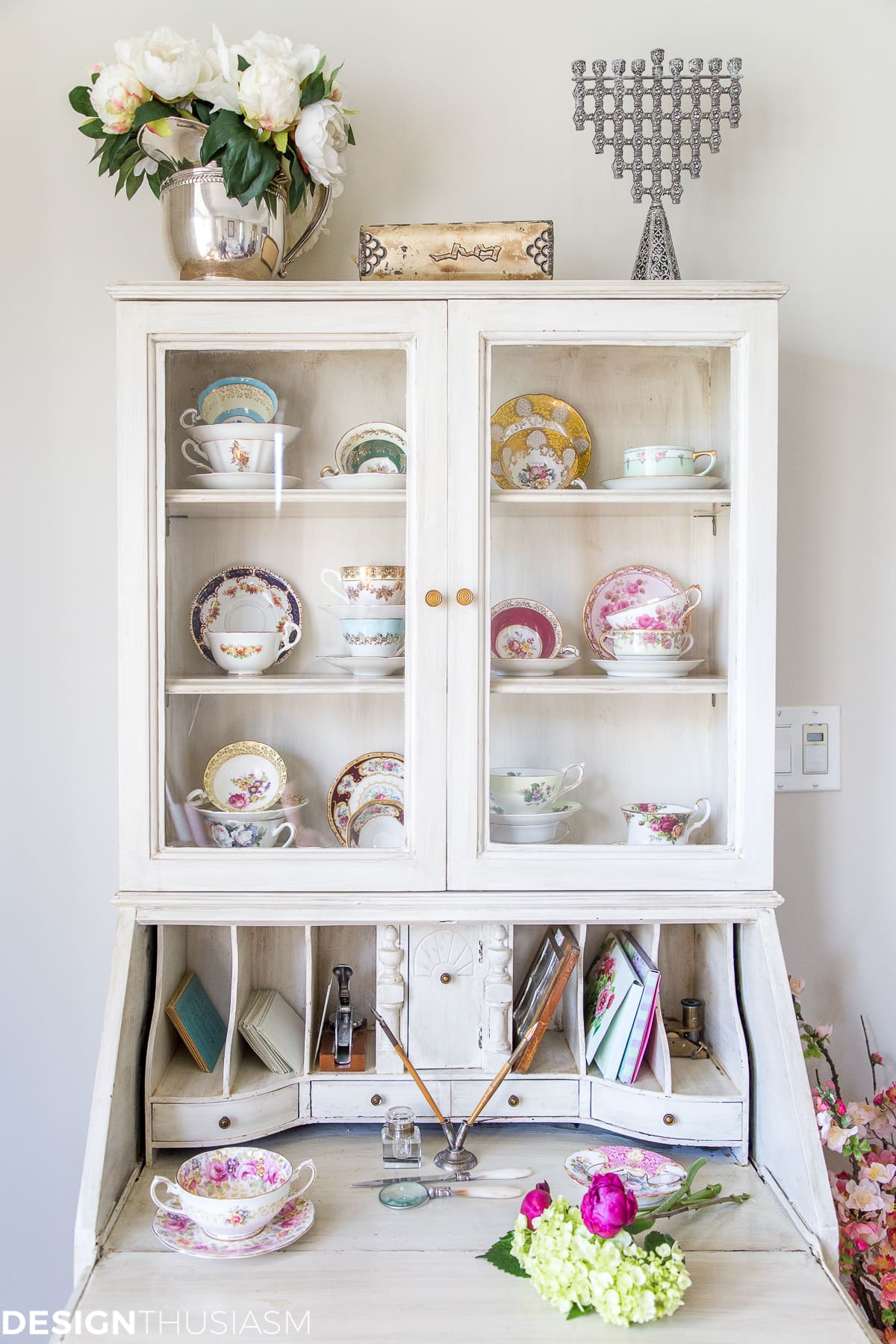 Vintage tea cups and plates on display in antique cabinets