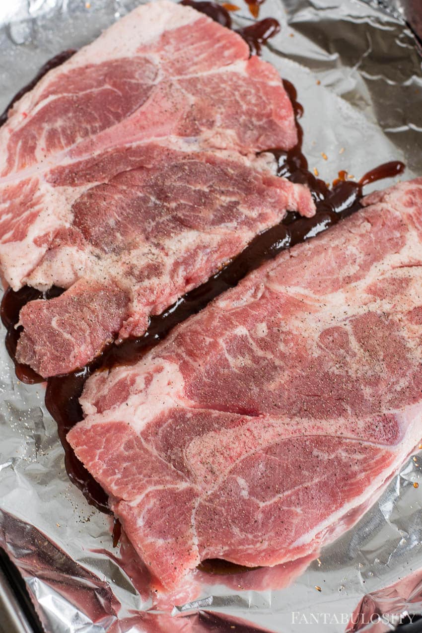 Raw pork with bbq sauce on baking sheet