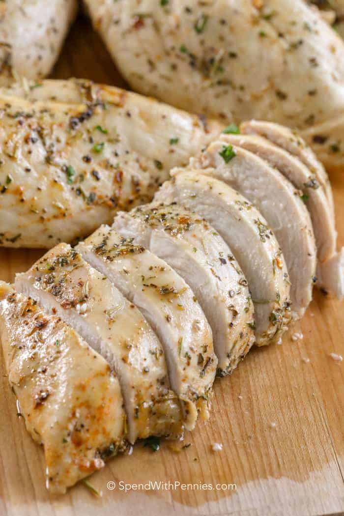 Grilled chicken diagonally sliced ​​to serve on wooden board