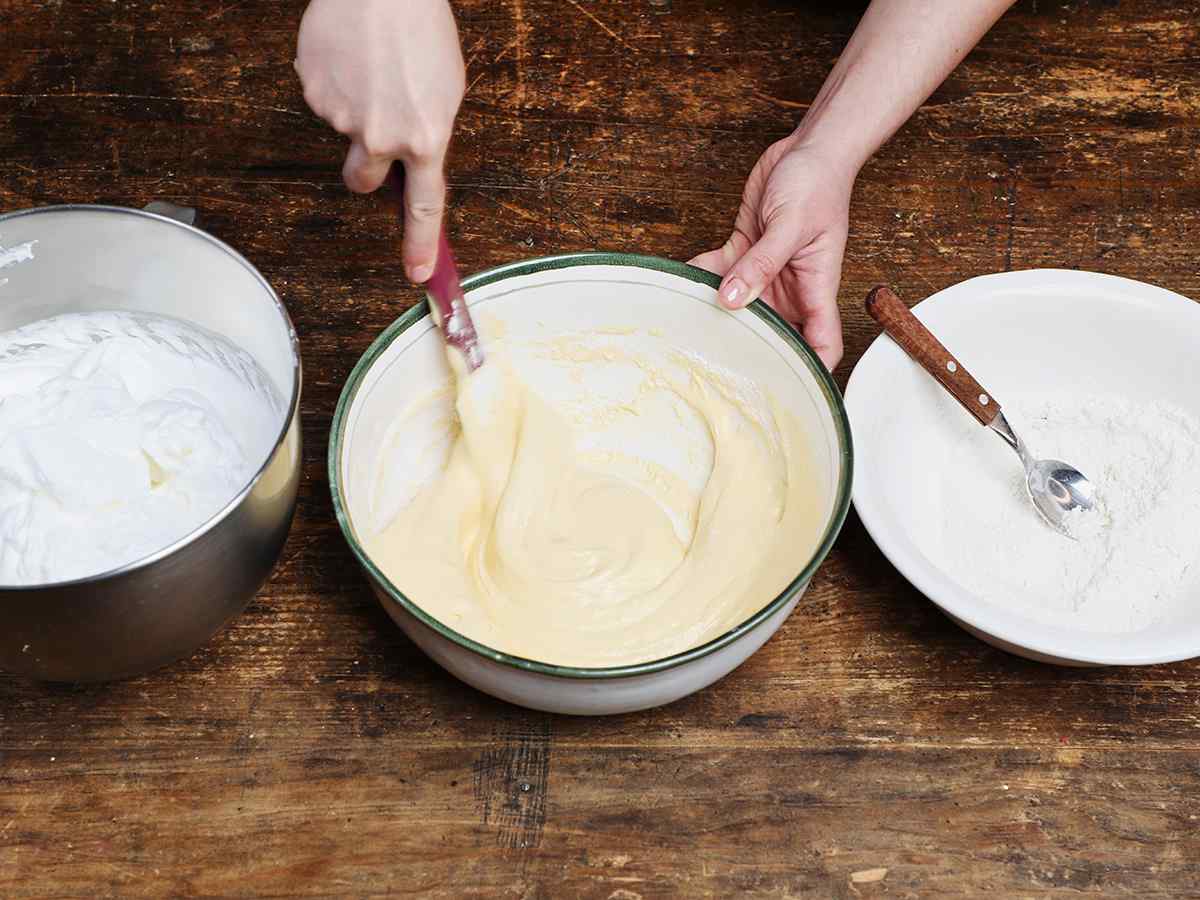 Stirring tres leches cake batter with spatula