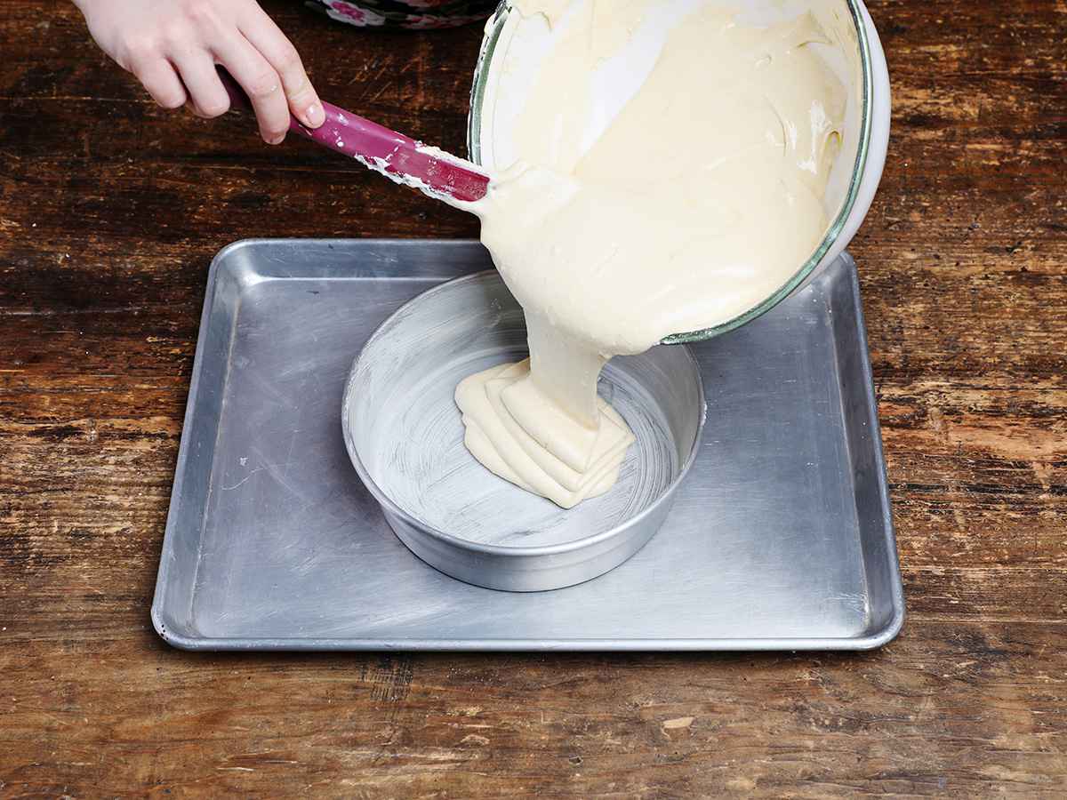 Pouring tres leches cake batter into prepared pan