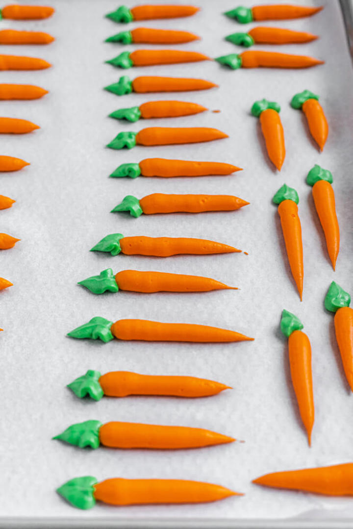 frosting carrots on parchment paper