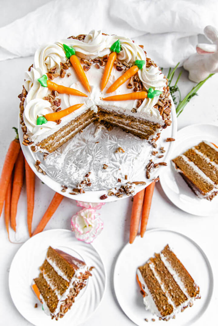 top view of sliced carrot cake with three slices on white plates
