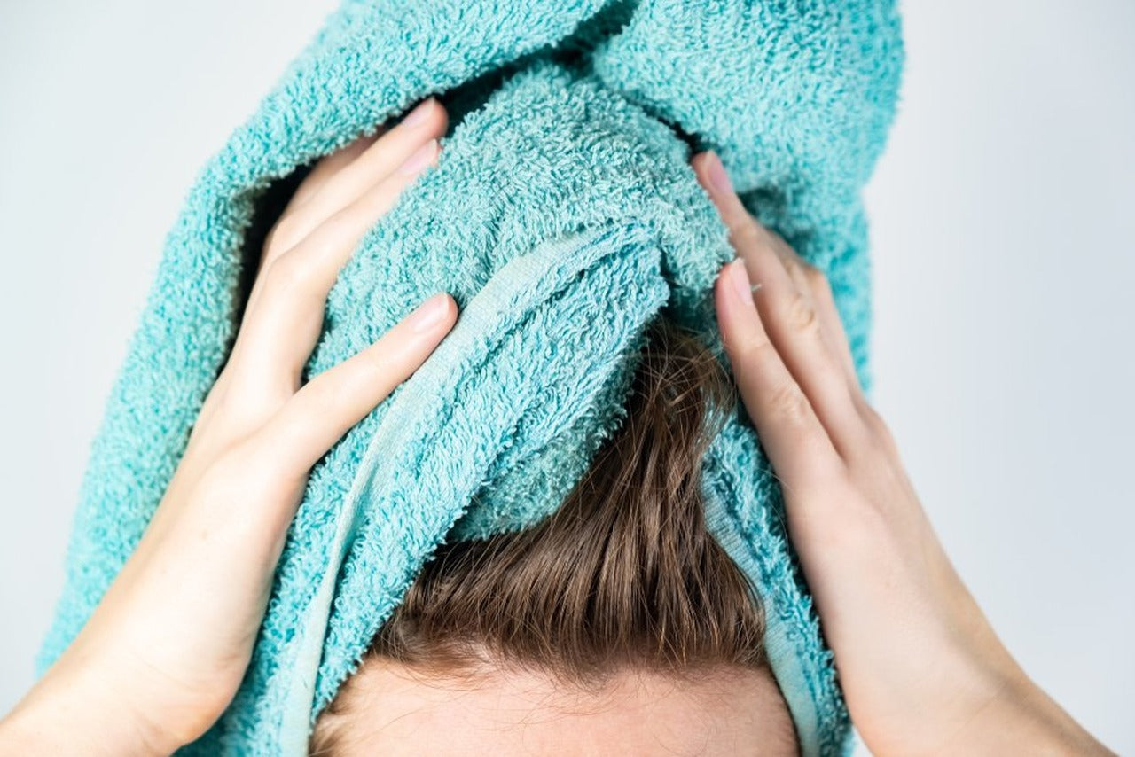 Woman holding a towel wrapped around her head