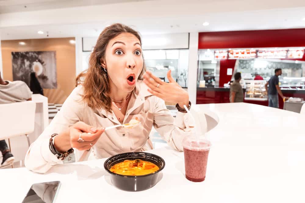 woman eating soup too hot and spicy