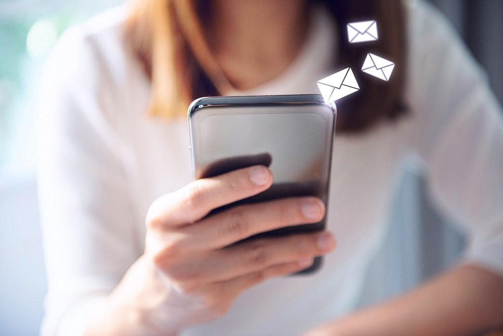 Woman using mobile smartphone with email icon.