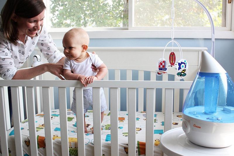 Image of a mother and baby in crib with humidifier