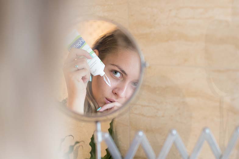 Woman applying moisturizer