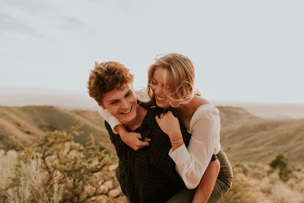 a guy giving girl a piggyback ride during engagement session