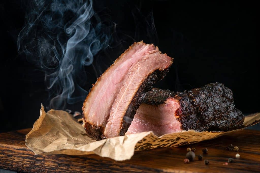 Sliced ​​smoked beef brisket with dark crust from classic bbq texas