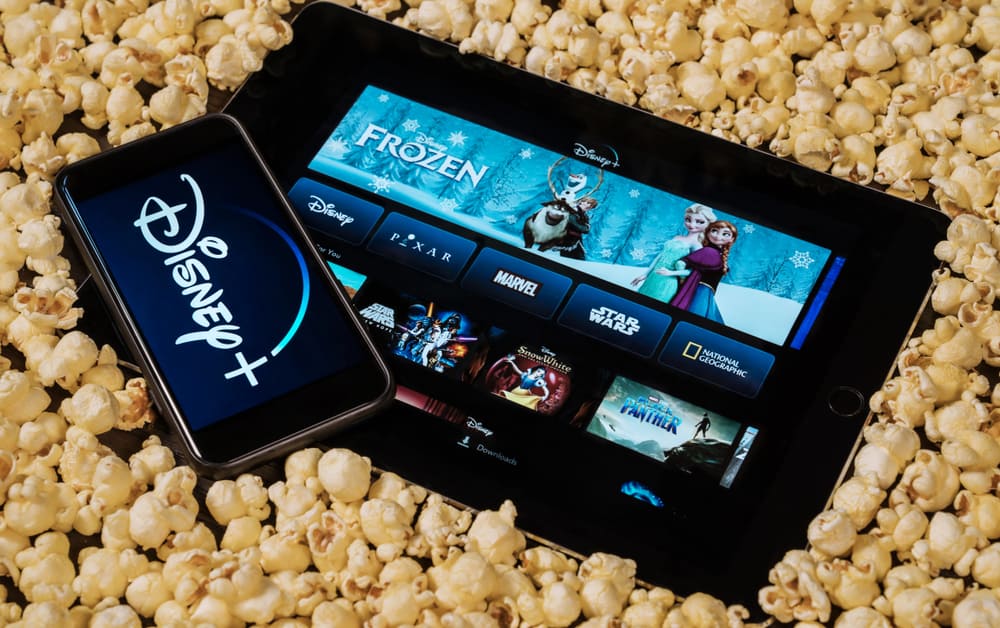 Disney plus on smartphone and iPad and tablet surrounded by popcorn